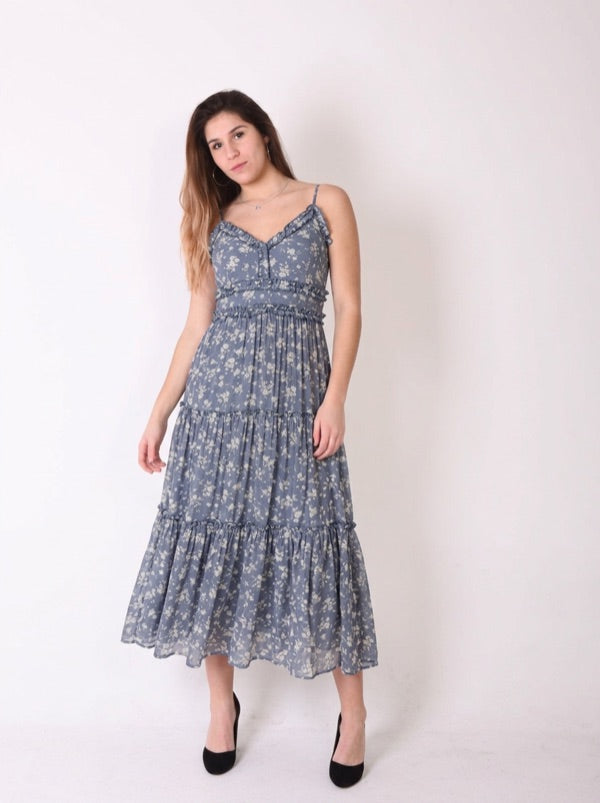 The same shopper wearing a blue floral tiered midi dress, made by AI from their photo