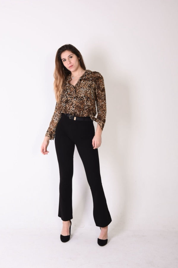 A shopper's full-length photo in a leopard print blouse and black trousers